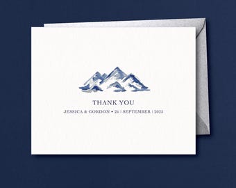 Könnte beinhalten: Eine weiße Dankeskarte mit einer Aquarell-Illustration von blauen Bergen. Der Text "Vielen Dank" ist unter den Bergen gedruckt, gefolgt von "Jessica & Gordon * 26 | September | 2025".