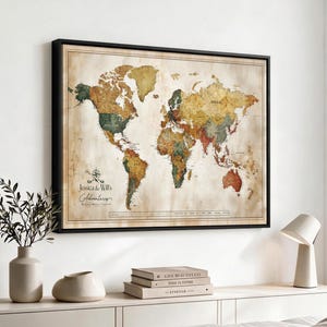 Puede incluir: Un mapa del mundo enmarcado con estética vintage, en tonos apagados de beige, verde y rojo. El mapa muestra continentes y países con etiquetas de texto. En la esquina inferior izquierda, el texto dice Jessica & Will's Adventures.