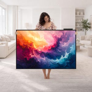 Puede incluir: Una gran pieza de arte mural rectangular que presenta una pintura abstracta fluida con remolinos vibrantes de colores naranja, amarillo, magenta, morado y azul profundo. La obra está enmarcada en un marco negro fino y muestra un patrón dinámico.