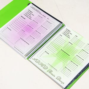 May include: Open spiral-bound notebook with a green cover and pages featuring a pink and green gradient. The notebook is labelled "ADHD Brain Dump" and includes checklists for daily tasks and goals. The text "Crush archive" is visible.