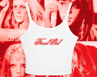 May include: White tank top with the text "Final Girl" in a red, cursive font. The top is set against a red background with images of women. The words "calling all final girls" are at the top.
