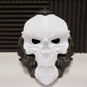 May include: A white and black skull mask with a menacing design. The mask features a prominent white skull face with black eye sockets and a black top. The sides of the mask are black with intricate details, creating a striking contrast.