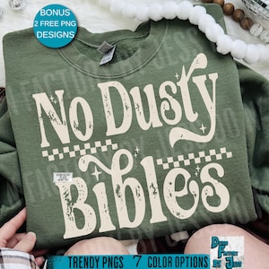 May include: A green sweatshirt with the text "No Dusty Bibles" in a vintage font. The design includes a checkered pattern and stars. The image also includes the text "BONUS 2 FREE PNG DESIGNS" and "TRENDY PNGS 7 COLOR OPTIONS BY JESS".