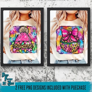 May include: Two framed images of graphic designs on t-shirts. One design features a pink winter hat with a pom-pom, leopard print, and string lights. The other design shows a pink bow on a Christmas ornament with leopard print. The background is a colorful watercolor design.