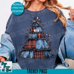 May include: A blue sweatshirt with a Christmas tree design. The tree is made from denim and red plaid fabric, decorated with floral details. The text "BONUS 2 FREE PNG DESIGNS" is in a circle at the top. The bottom of the sweatshirt has the text "TRENDY PNGS".