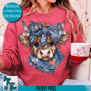 May include: A red sweatshirt with a cow illustration wearing a denim bow and scarf with heart accents. The image includes the text "BONUS 2 FREE PNG DESIGNS" and "TRENDY PNGS". A white mug with red trim and heart designs is held in the image.