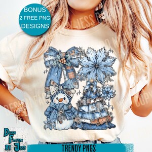 May include: Cream-coloured t-shirt with a winter-themed graphic. The design features a snowman, a Christmas tree, and a snowflake, in blue and brown hues. The text "BONUS 2 FREE PNG DESIGNS" is in a blue circle, and "TRENDY PNGS" is in a teal rectangle.