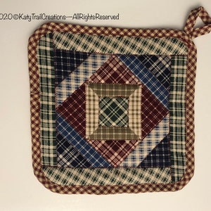 May include: A square quilted hot pad with a patchwork design in shades of blue, green, red, and beige. The hot pad has a brown and beige gingham border and a loop handle.