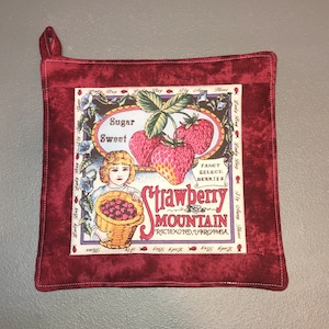 May include: Red quilted hot pad with a vintage illustration of strawberries and the text "Sugar Sweet Strawberry Mountain Richmond, Virginia".