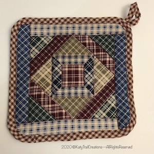 May include: Square quilted potholder with a plaid pattern in shades of blue, green, burgundy, and tan. The potholder has a gingham border and a loop for hanging. The text "2020 Katy Trail Creations - All Rights Reserved" is at the bottom.