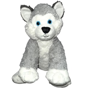 Può includere: Un peluche a forma di cane husky con pelo grigio e bianco, occhi blu e naso nero. L'animale di peluche è seduto con le zampe anteriori e le orecchie dritte. Il giocattolo è progettato per assomigliare a un vero husky.