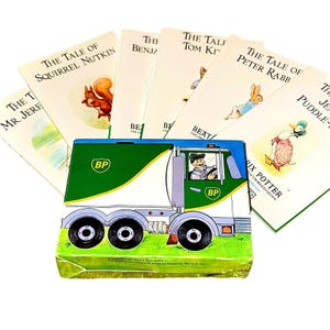 May include: A collection of children's books featuring illustrations of animals, including a squirrel, rabbit, and duck. The books are displayed with a green, white, and blue BP truck-shaped box. The books are by Beatrix Potter.
