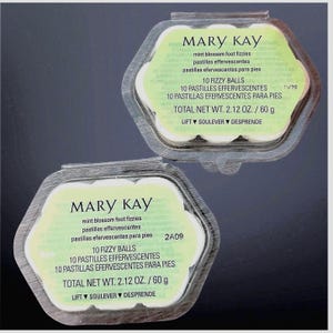 May include: Two hexagonal clear plastic containers of Mary Kay mint blossom foot fizzies. Each package contains 10 fizzy balls with a total net weight of 60 g. The labels feature green text on a light green background with instructions to lift.