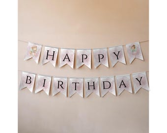 May include: A banner with the words "HAPPY BIRTHDAY" printed in black on white pennants. The pennants have a watercolor-like pink and white background. The banner is strung on a thin white string.
