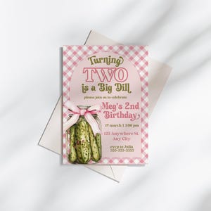 May include: A pink and white gingham-patterned birthday invitation with the text "Turning TWO is a Big Dill." The invitation features a watercolor illustration of a jar of pickles tied with a pink bow. The invitation is for Meg's 2nd birthday.
