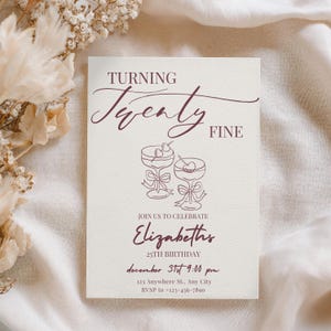 Puede incluir: Una tarjeta de invitaci&oacute;n color crema con texto burdeos. Dice "TURNING Twenty FINE" y presenta dos copas de c&oacute;ctel. Debajo, dice "JOIN US TO CELEBRATE Elizabeths 25th Birthday December 31st 9:00 pm".