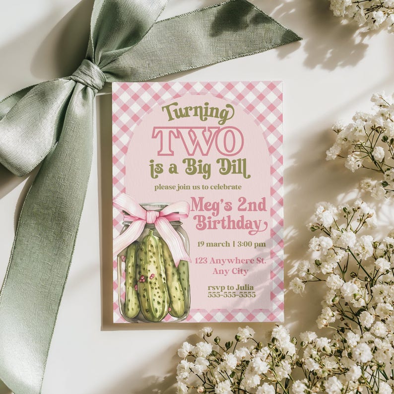 May include: A pink and white gingham birthday invitation with the text "Turning TWO is a Big Dill." The invitation features a watercolor illustration of pickles in a jar and a pink bow. White flowers and a green ribbon are in the background.