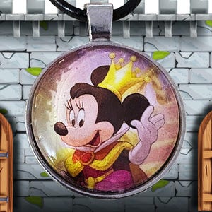 Puede incluir: Colgante redondo plateado con una imagen de dibujos animados de Minnie Mouse con corona y vestimenta real. El colgante cuelga de un cord&oacute;n negro. El fondo es una pared de castillo.