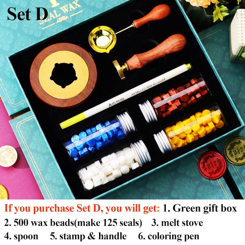 May include: A wax seal kit in a teal box, including a wooden handle stamp, a brass spoon, a melting stove, and a white pen. The kit also contains glass vials filled with colorful wax beads in red, yellow, blue, and white. The text "Set D" is visible.