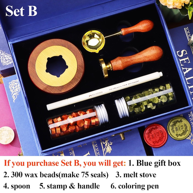 May include: A blue gift box set containing a wax seal kit. The kit includes a wooden and brass wax warmer, a brass stamp with a wooden handle, a spoon, a coloring pen, and two vials of wax beads. The text "Set B" is visible.