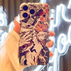Op de afbeelding: Een witte telefoonhoes met een manga-stijl illustratie van een personage met rood haar en een gespierd lichaam. Het ontwerp bevat zwart-wit stripboekpanelen en Japanse tekst, wat een dynamische en gedetailleerde esthetiek cre&euml;ert.