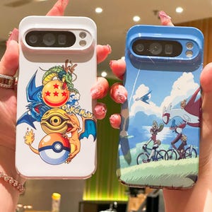 May include: Two phone cases are shown. One is white with a Pokemon design featuring a dragon, a Charizard, and a Poke Ball. The other is blue with a scenic Pokemon design of characters riding bikes.