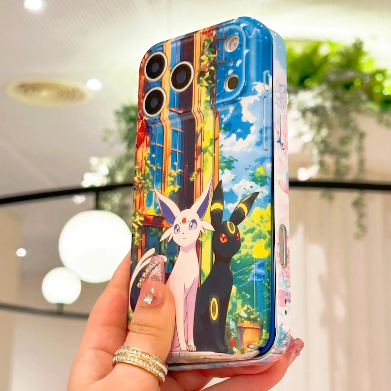 May include: A phone case with a colourful illustration of two cartoon characters, one white and one black, set against a building and a blue sky. The case has a glossy finish and a protective design.
