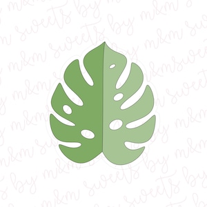 May include: A light green, stylized Monstera leaf cookie cutter. The leaf is divided into two halves, with several oval-shaped holes. The cutter is designed for creating tropical-themed cookies or decorations.