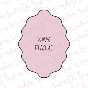 May include: A pink, wavy plaque cookie cutter with the words "WAVY PLAQUE" in black, centered within the shape. The cutter has a black outline and is set against a white background with a repeating script pattern.