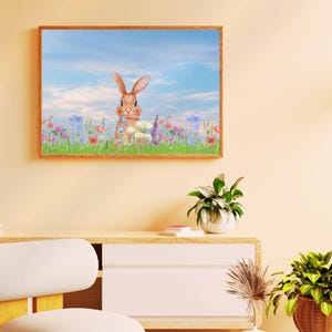 May include: A framed print featuring a watercolor painting of a brown rabbit in a field of colorful wildflowers. The background shows a blue sky with wispy clouds. The artwork is in a wooden frame, suitable for home decor.
