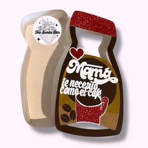 May include: A beige and brown coffee-shaped decoration with the text "Mamá te necesito como el café" and a red heart. The decoration has a red glitter top and a sticker that says "The Sweets Bar".