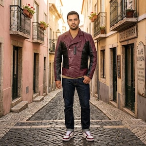 May include: A burgundy and black leather jacket with a unique design, paired with dark blue jeans and white sneakers with burgundy accents. The jacket features a distinctive asymmetrical closure and a textured pattern.