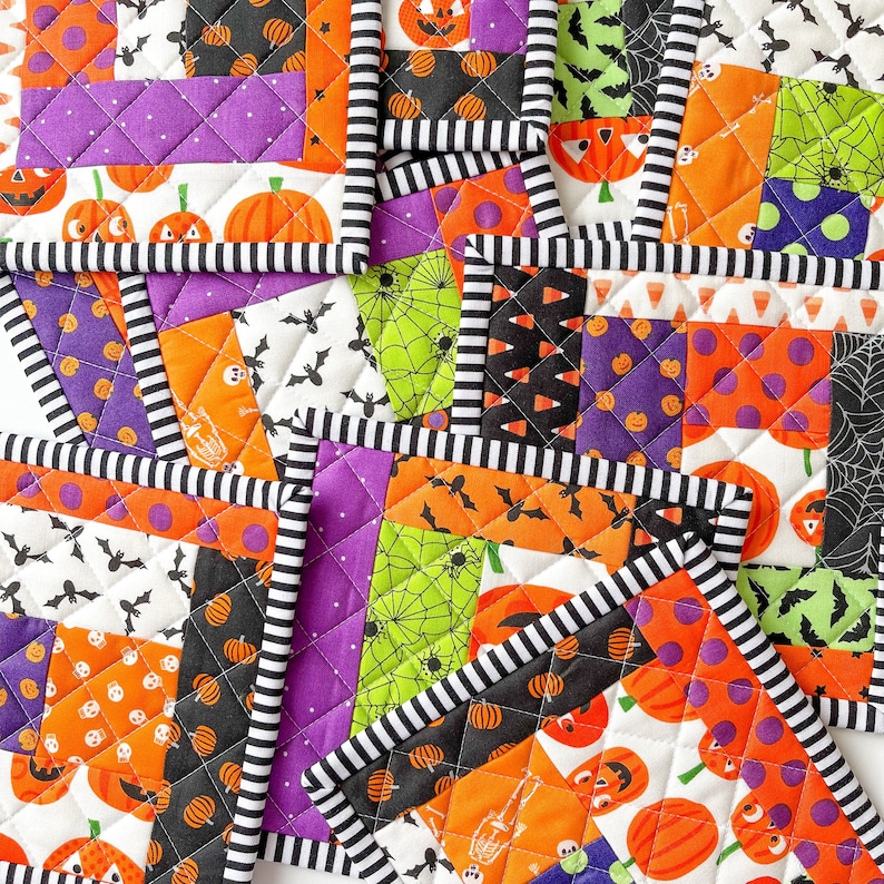 May include: A set of eight Halloween-themed quilted pot holders. The pot holders feature a variety of patterns, including bats, pumpkins, and candy corn. The pot holders are made with a black and white striped trim.