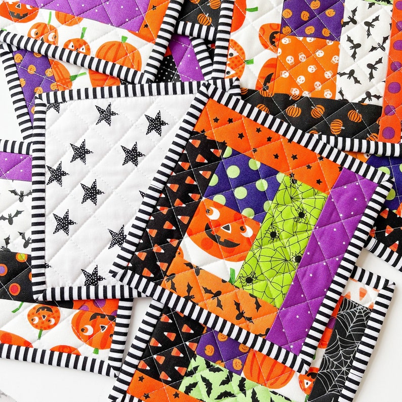 May include: Set of four Halloween-themed quilted pot holders. Each pot holder features a different patchwork design with orange, purple, black, green, and white fabrics. The designs include pumpkins, bats, spiders, and candy corn.