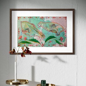 May include: Framed artwork featuring two animal skulls in shades of green and tan, set against a map-like background with floral accents. The skulls are detailed with visible teeth and bone structure, framed in a dark wood.