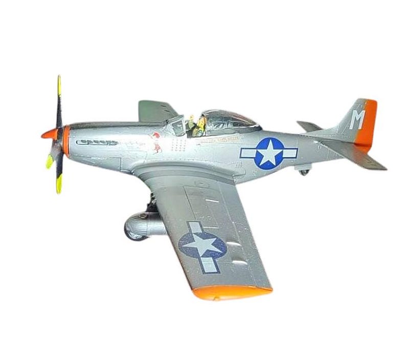 May include: A silver model airplane with orange and yellow accents. The plane features a blue star insignia on the wings and fuselage. The propeller is yellow and black. The tail has an orange tip with the letter "M".