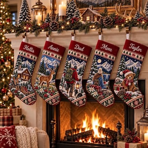 May include: Five personalized Christmas stockings hanging from a fireplace mantel. Each stocking features a deep red cuff with a name embroidered in white: Hollis, Annie, Dad, Mom, and Taylor. The bodies display detailed winter mountain scenes.