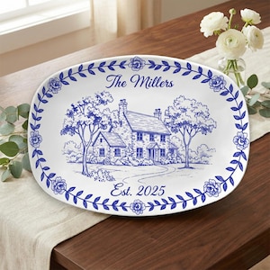 May include: Oval white serving platter with a blue floral border and a detailed blue illustration of a house and trees. The text "The Millers" and "Est. 2025" are also displayed in blue.