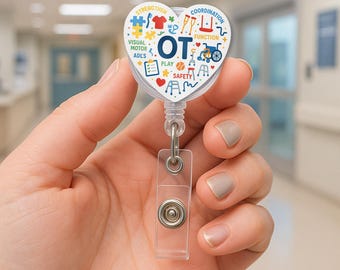 Może przedstawiać: Brelok do identyfikatora w kształcie serca z literami "OT" w kolorze niebieskim, otoczony kolorowymi ikonami i tekstem związanym z terapią zajęciową. Brelok ma przezroczysty plastikowy pasek i chowany sznurek.