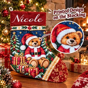 Pode incluir: Uma meia de Natal vermelha e azul com o nome Nicole em letra branca. A meia exibe um urso de peluche com gorro e fato de Pai Natal, rodeado por &aacute;rvores de Natal, presentes e estrelas. O texto diz Printed Design on the Stocking.
