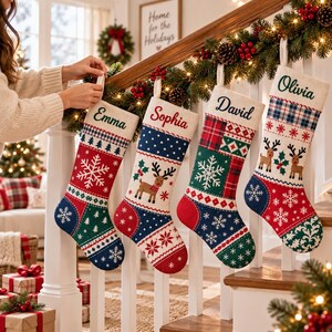 Pode incluir: Quatro meias de Natal personalizadas penduradas num corrim&atilde;o de escada de madeira branca. Cada meia apresenta um design de patchwork &uacute;nico com padr&otilde;es festivos, incluindo flocos de neve, renas e xadrez, com os nomes Emma, Sophia, David e Olivia bordados.