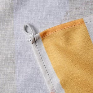May include: A kitchen towel featuring a woven fabric texture with a light gray and white striped pattern. The towel includes a prominent yellow vertical stripe and a small white fabric loop attached to the corner for hanging purposes.