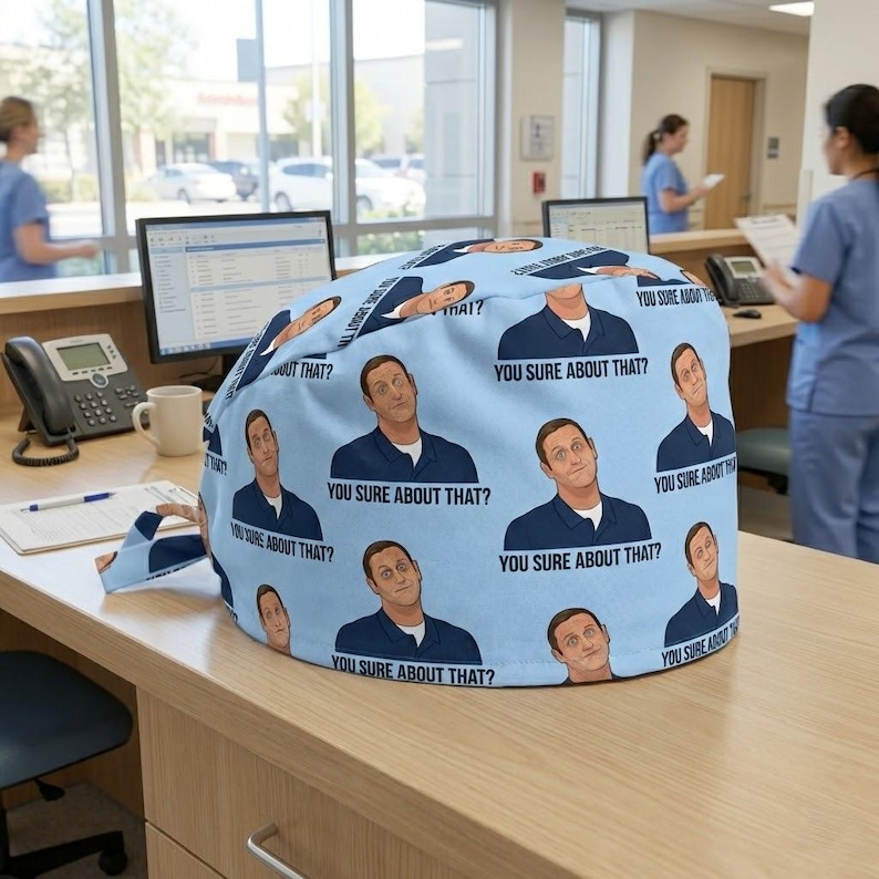 May include: A light blue scrub cap featuring a repeating pattern of a man in a dark blue polo shirt with the text "YOU SURE ABOUT THAT?" printed underneath each illustration. The fabric is patterned with multiple instances of this graphic design.