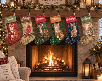 Pode incluir: Seis meias de Natal personalizadas penduradas numa lareira de madeira. Cada meia apresenta uma ilustração animal única: raposa, cardeal, veado, gato, coelho e coruja, com os nomes Emma, Johnny, Annie, Oliver, Adalyn e Watson bordados.