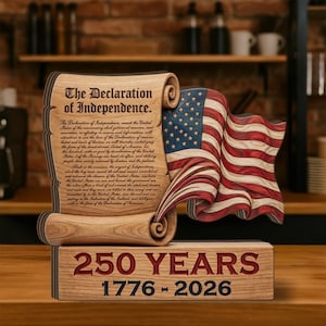May include: Wooden decorative piece featuring the Declaration of Independence and a waving American flag. The text "250 YEARS 1776-2026" is displayed on the base. The piece is made of wood and has a rustic appearance.
