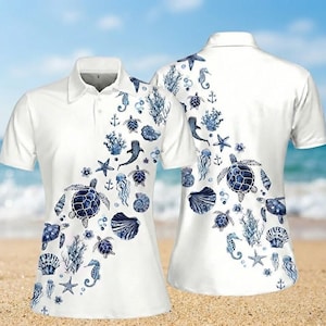May include: White polo shirt with a blue sea life pattern, including turtles, starfish, and seahorses. The design is printed on the front and back of the shirt, creating a nautical theme.
