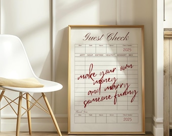 May include: A framed print resembling a guest check, featuring the words "Guest Check" at the top and "make your own money and marry someone funny" in a cursive font. The frame is gold.