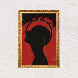 Op de afbeelding: Een ingelijste kunstdruk met een zwart silhouet van een hoofd en schouders tegen een rode achtergrond. Een gouden, sierlijke lijst omringt het kunstwerk. Het hoofd van de persoon is omcirkeld door een witte lijn.
