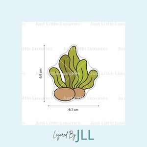 May include: A sticker with a green and brown plant design. The sticker is 6.9 cm high and 6.1 cm wide. The text "Layered By JLL" is at the bottom of the image.