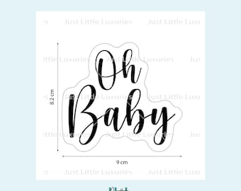 Puede incluir: Un diseño negro y cursivo de "Oh Baby", de 9 cm de ancho y 8,2 cm de alto, para decoraciones de baby shower. El diseño está sobre un fondo blanco con el texto "Just Little Luxuries" repetido.